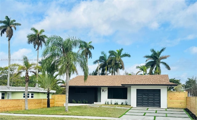 single story home with a garage and a front lawn