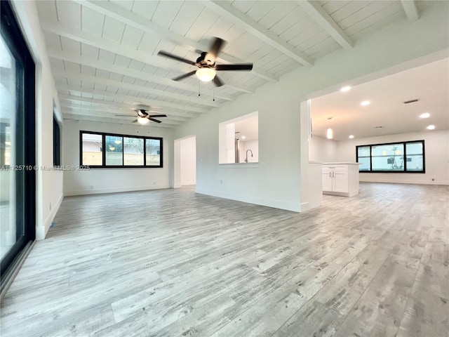 unfurnished living room with wooden ceiling, light hardwood / wood-style floors, beamed ceiling, and plenty of natural light