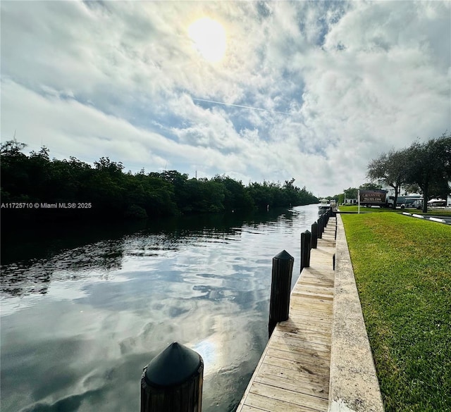 dock area featuring a water view and a lawn