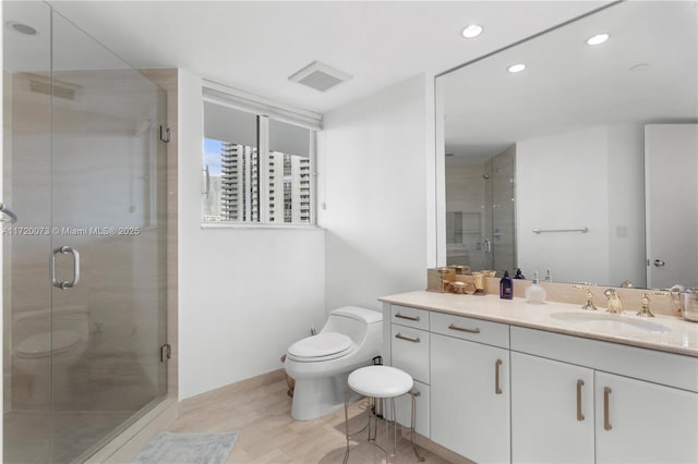 bathroom featuring walk in shower, hardwood / wood-style flooring, vanity, and toilet