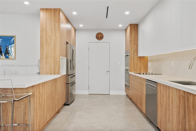 kitchen featuring stainless steel appliances, white cabinets, and sink