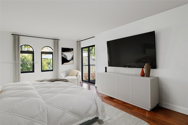 bedroom featuring french doors, hardwood / wood-style floors, multiple windows, and access to exterior