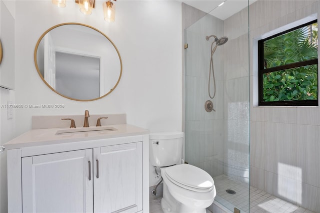 bathroom featuring toilet, tiled shower, and vanity