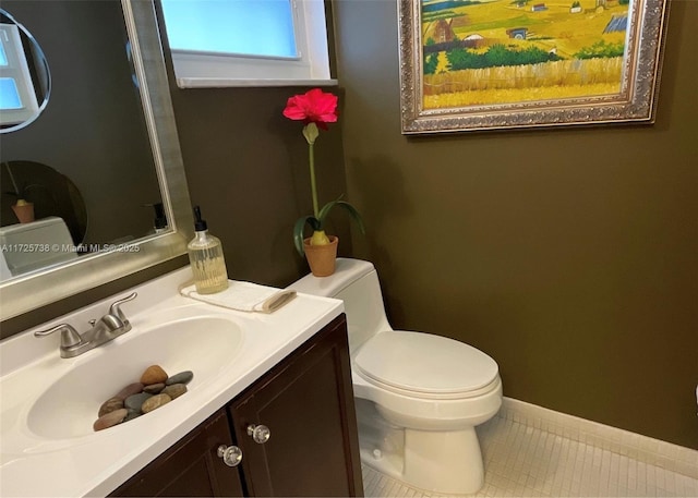 bathroom with tile patterned flooring, vanity, and toilet