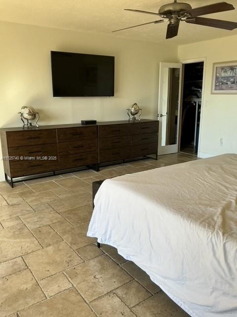 bedroom with ceiling fan, a walk in closet, and a closet