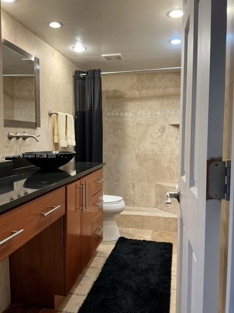 bathroom featuring a shower with shower curtain, tile patterned floors, vanity, and toilet