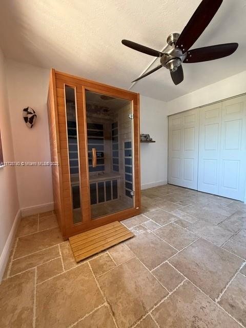 interior space with ceiling fan