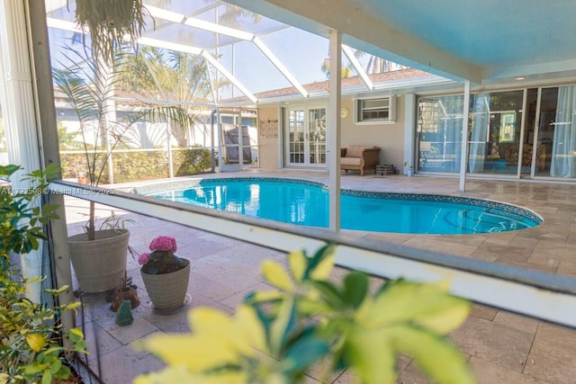 view of pool with a lanai, french doors, and a patio area