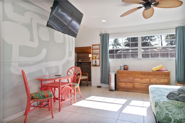 interior space featuring ceiling fan, crown molding, and light tile patterned floors