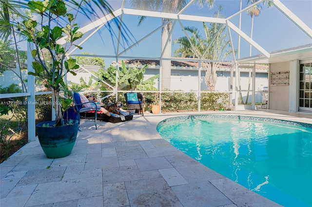 view of pool with a patio area and a lanai