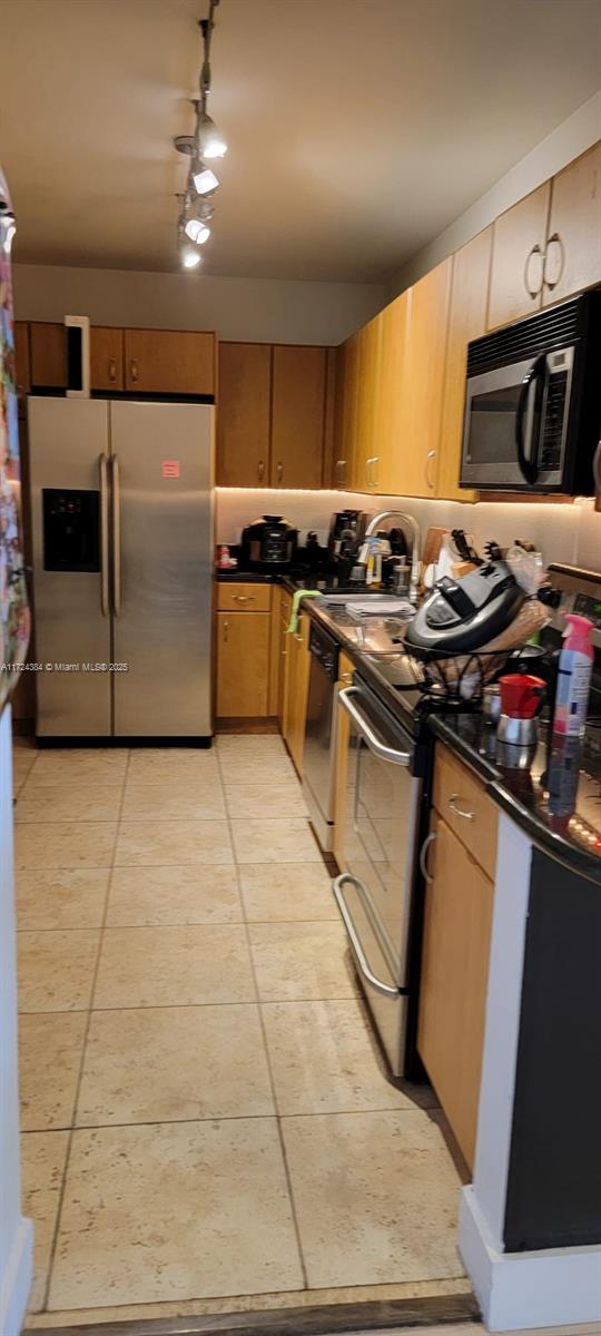 kitchen featuring stainless steel appliances, light tile patterned flooring, and sink