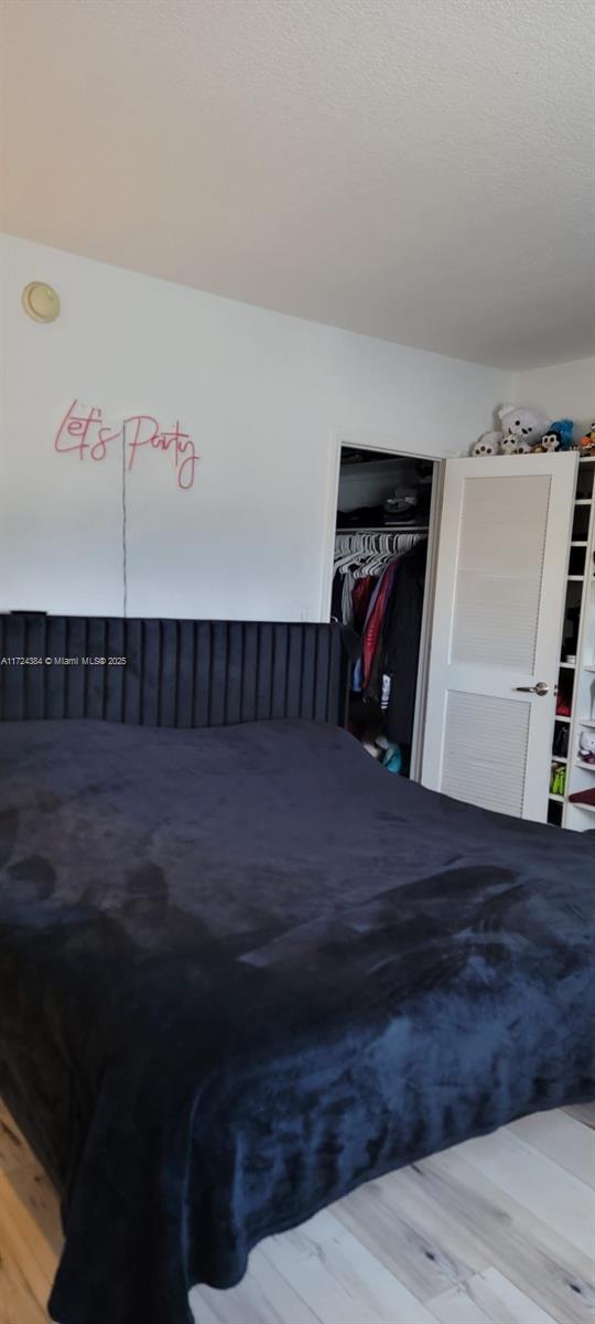 bedroom featuring hardwood / wood-style floors and a closet