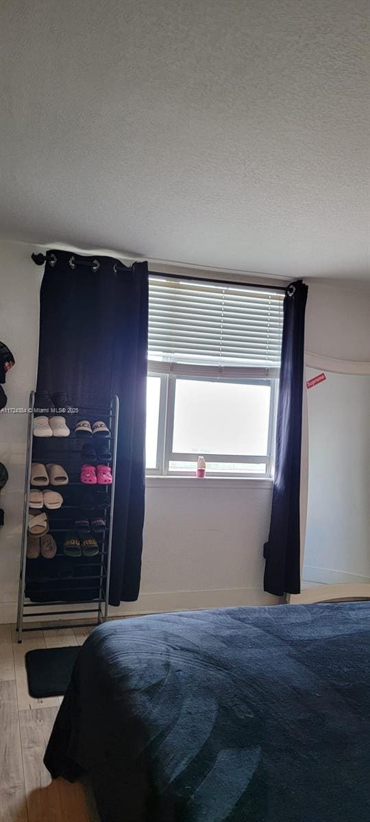 bedroom featuring a textured ceiling and wood-type flooring