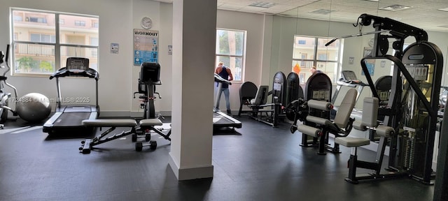 workout area featuring a healthy amount of sunlight and a paneled ceiling