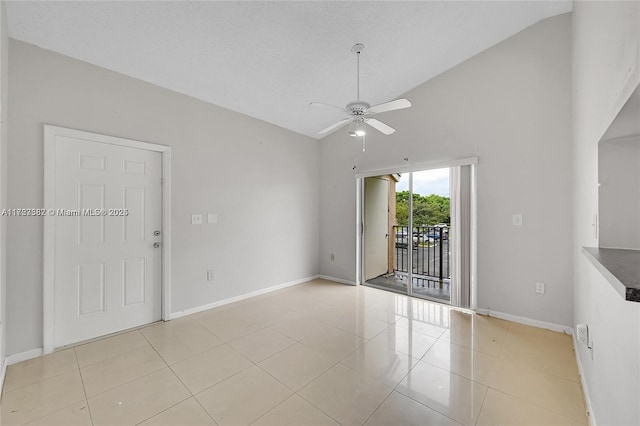 spare room with lofted ceiling, a textured ceiling, ceiling fan, and light tile patterned floors