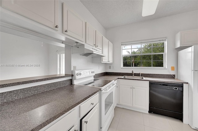 kitchen with white appliances, light tile patterned floors, a textured ceiling, white cabinets, and sink