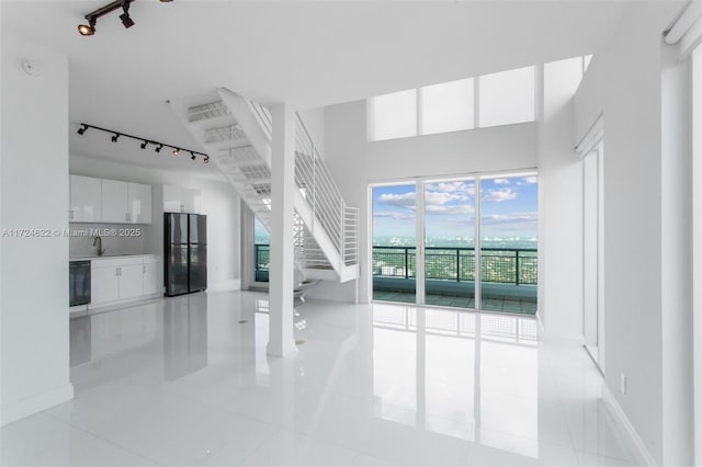 unfurnished living room with light tile patterned floors and sink