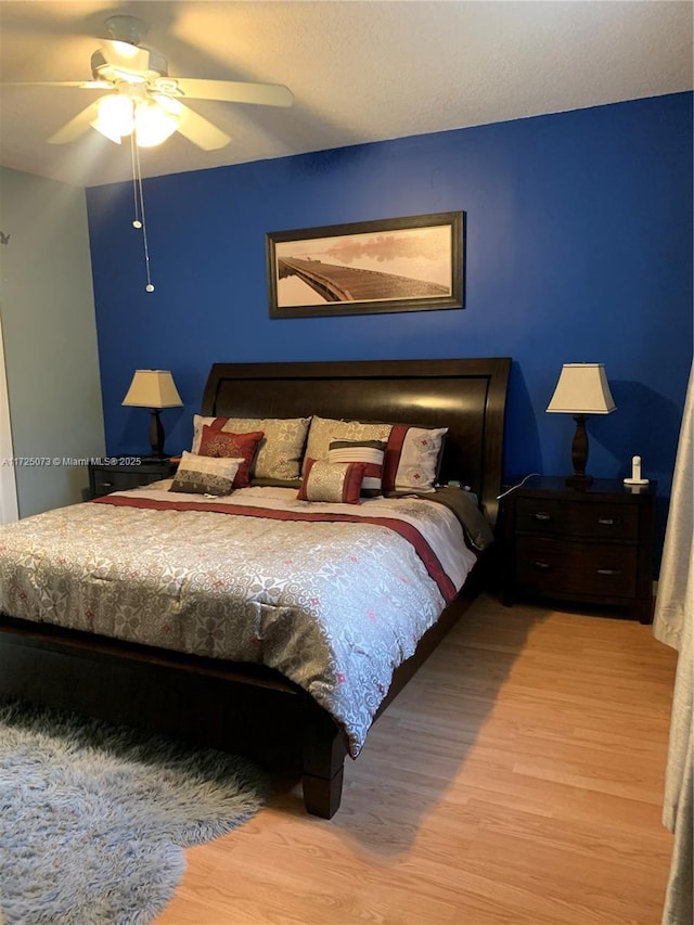 bedroom with ceiling fan and light hardwood / wood-style floors