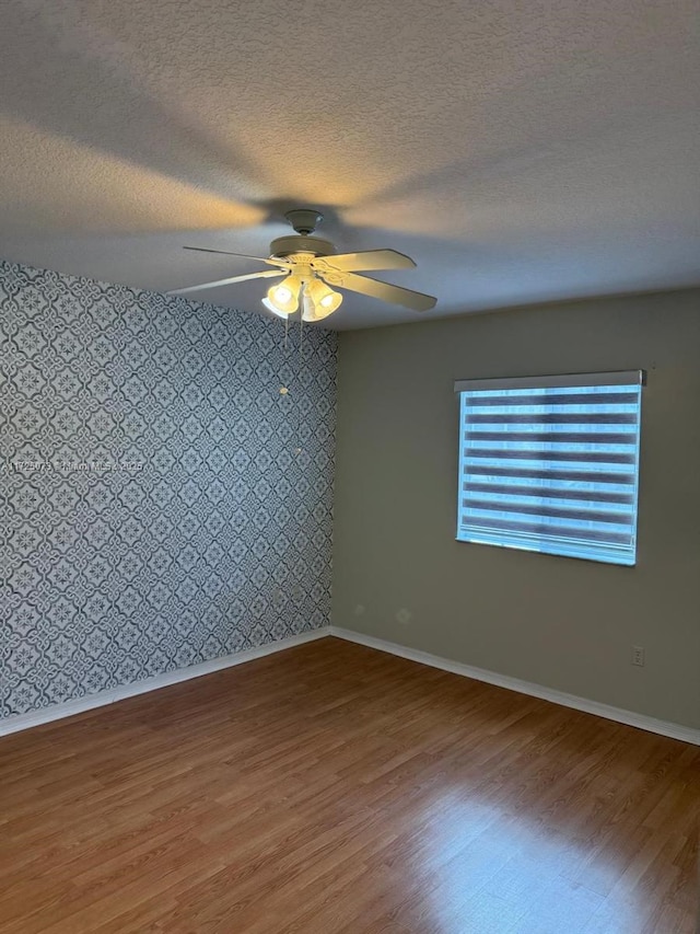 unfurnished room with hardwood / wood-style floors, a textured ceiling, and ceiling fan