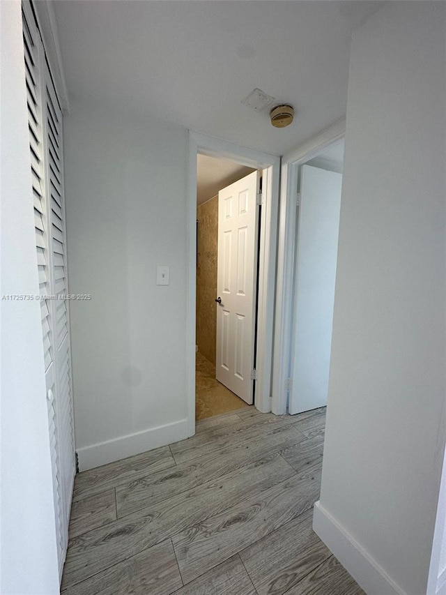 hallway with light hardwood / wood-style floors