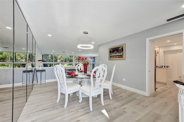 dining area featuring expansive windows and light wood-type flooring