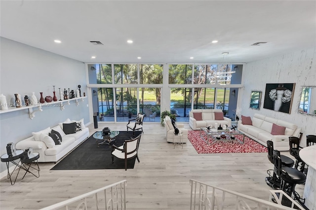 living room featuring a wall of windows and light wood-type flooring