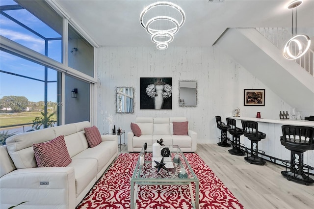 living room with light wood-type flooring and an inviting chandelier