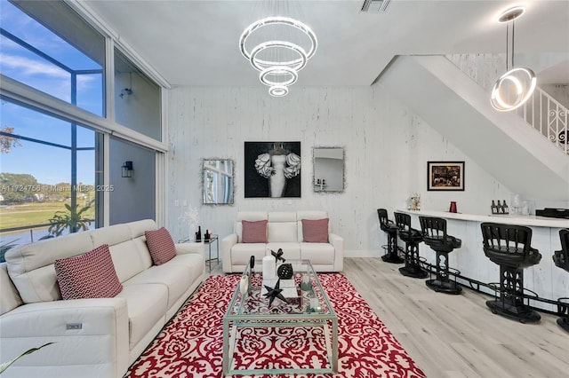 living room featuring a notable chandelier and light wood-type flooring