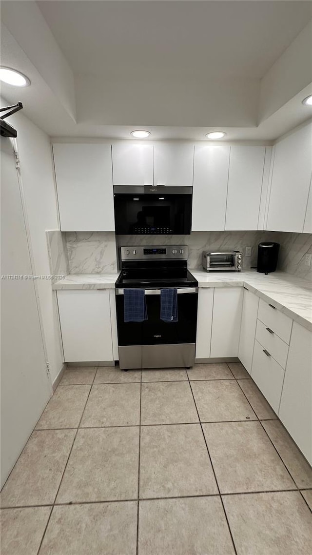 kitchen featuring white cabinets, stainless steel range with electric cooktop, and light tile patterned floors