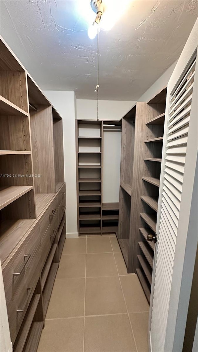 spacious closet featuring light tile patterned floors