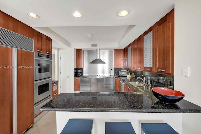 kitchen with sink, stainless steel appliances, kitchen peninsula, and a kitchen bar