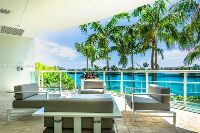 balcony with a water view and an outdoor hangout area