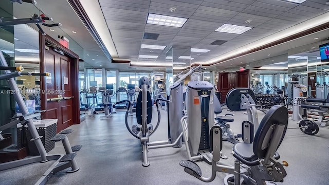 workout area with a paneled ceiling and a raised ceiling