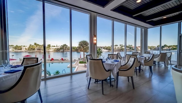 sunroom / solarium with a water view and beam ceiling