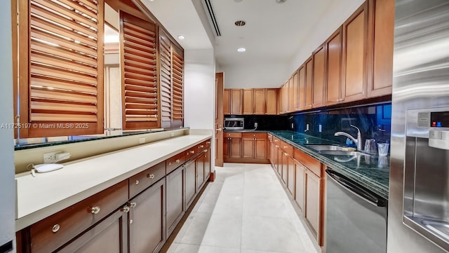 kitchen with tasteful backsplash, sink, light tile patterned floors, and stainless steel appliances