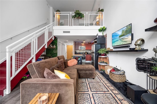 living room with a high ceiling and hardwood / wood-style flooring