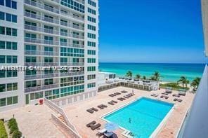 view of pool with a patio area and a water view