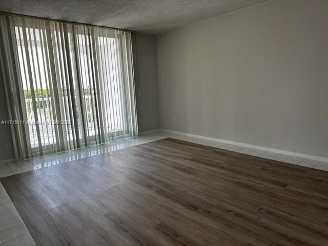 unfurnished room with a wall of windows and a textured ceiling