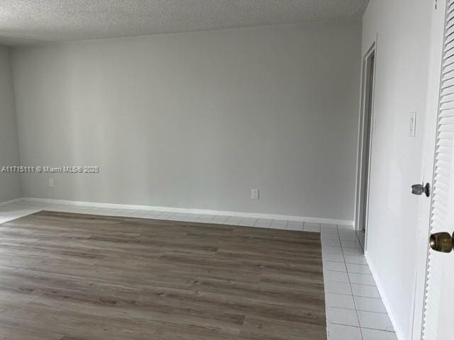 empty room featuring a textured ceiling and tile patterned flooring