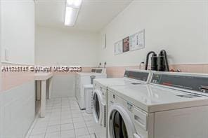 laundry room with independent washer and dryer and light tile patterned floors