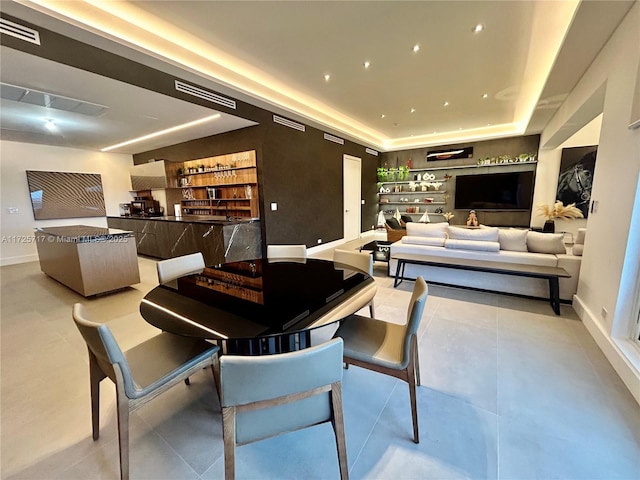 dining area featuring light tile patterned floors and a tray ceiling