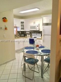 kitchen featuring white cabinetry, white appliances, light tile patterned floors, and tasteful backsplash