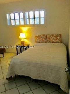 tiled bedroom with multiple windows