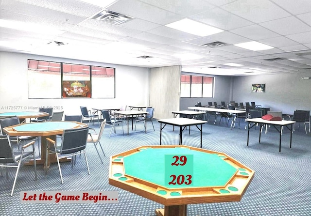 game room with a paneled ceiling and carpet