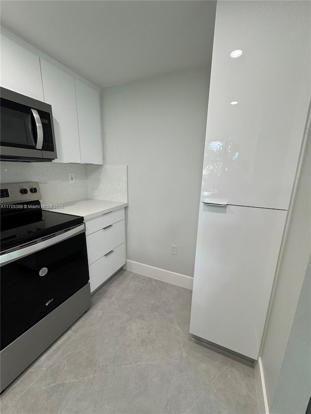 kitchen featuring white cabinetry, appliances with stainless steel finishes, and decorative backsplash