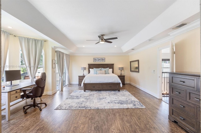 bedroom with ceiling fan, wood-type flooring, a raised ceiling, and multiple windows