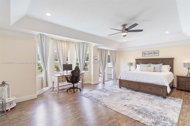 bedroom featuring hardwood / wood-style flooring, ceiling fan, crown molding, and a raised ceiling