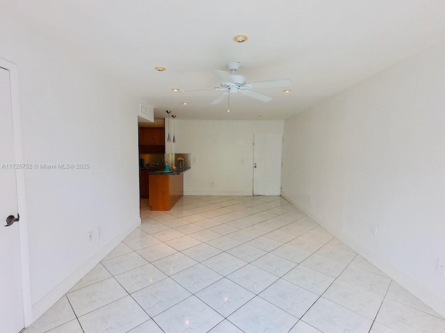 spare room with ceiling fan and light tile patterned floors