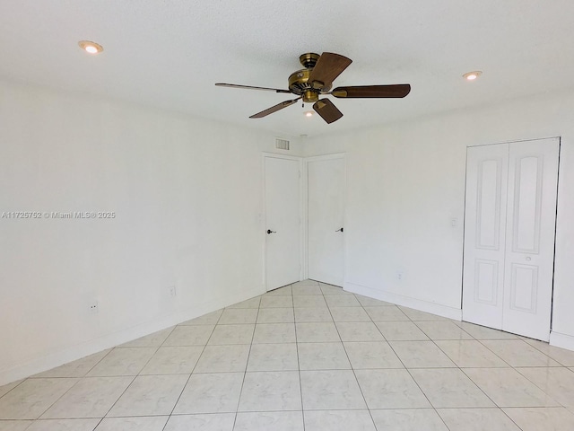 tiled spare room featuring ceiling fan