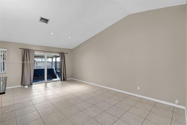 unfurnished room featuring lofted ceiling and light tile patterned floors